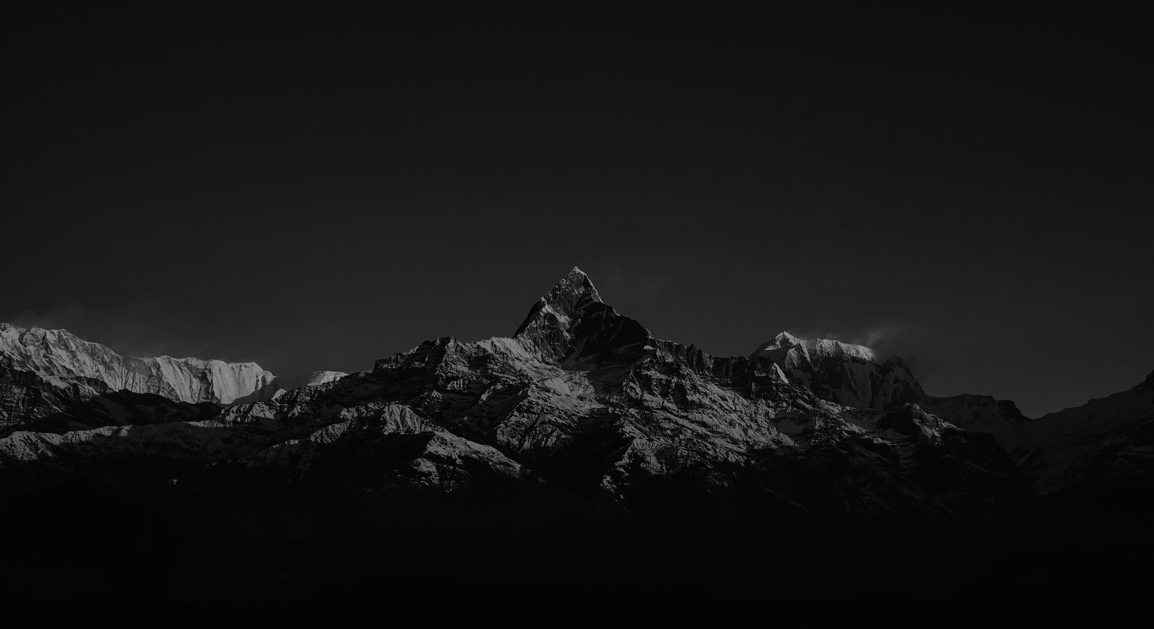 A dark, stylized mountain vista